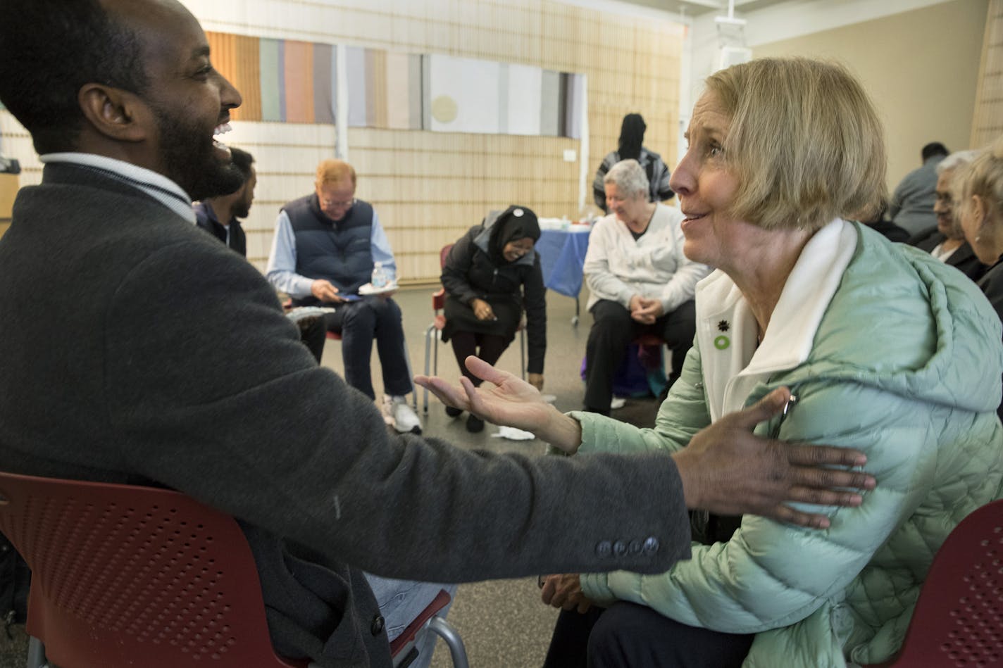 Hassan Yussuf, St. Cloud and Lea Iverson, Elk River, talk and exchange contact information after the &#xd2;Dine and Dialogue: How to Build a Better Minnesota&#xd3; event Saturday, April 6, 2019, at the St. Cloud Public Library in St. Cloud, MN.