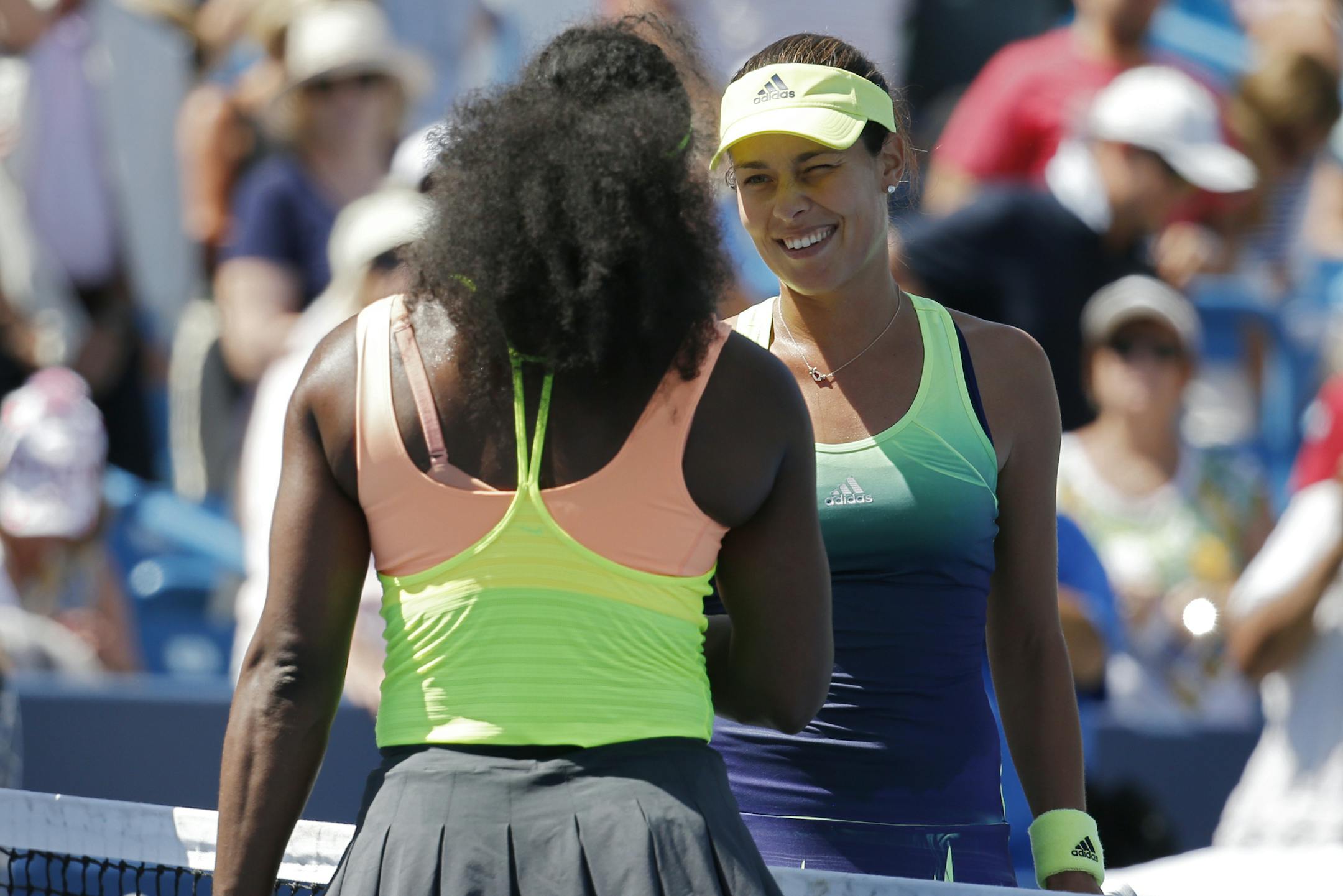 Ana Ivanovic, of Serbia, right, winks as she shakes hands with Serena Williams, after losing their quarterfinal match at the Western & Southern Open tennis tournament, Friday, Aug. 21, 2015, in Mason, Ohio. (AP Photo/John Minchillo)