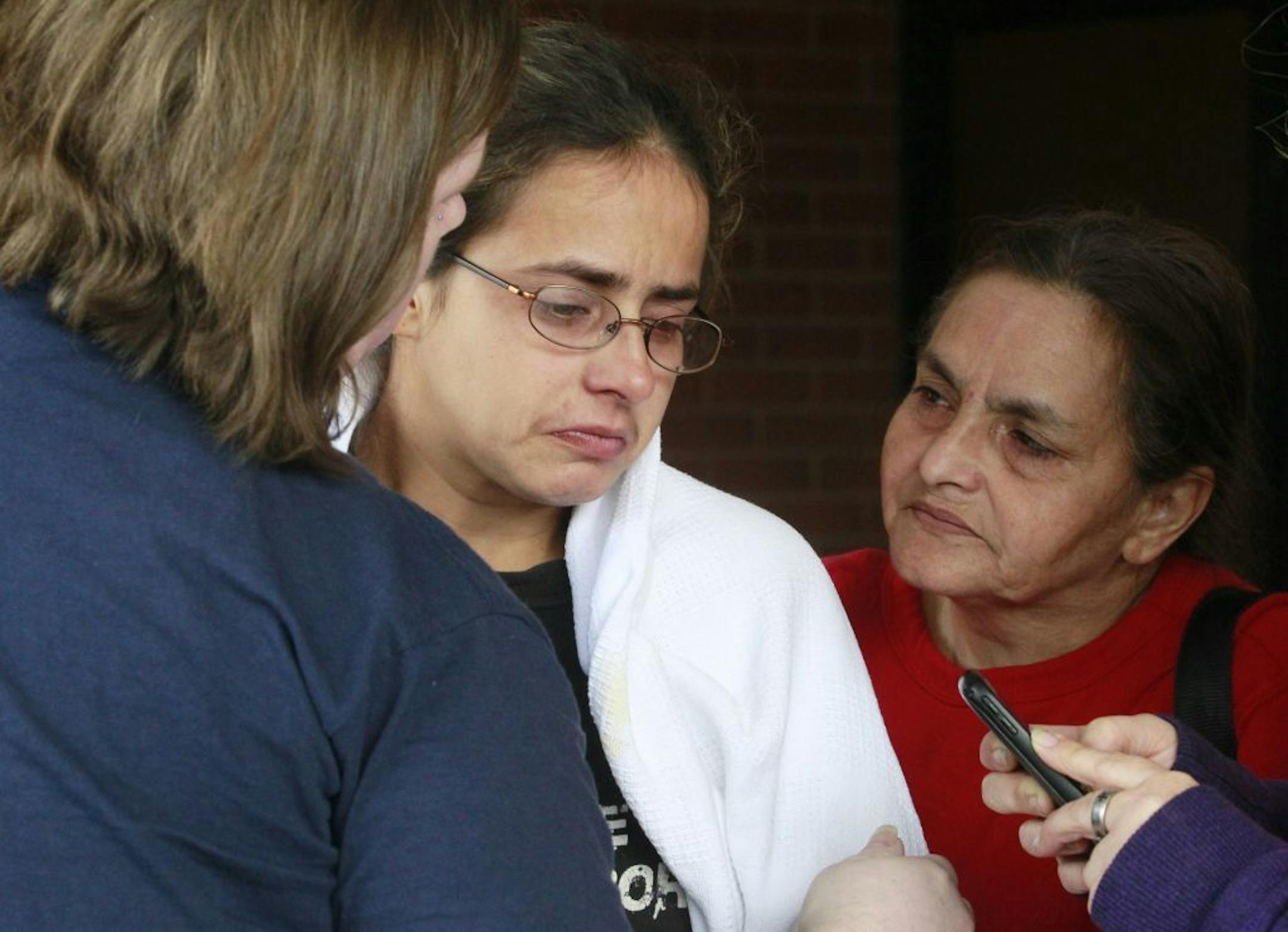 Anna Angel, right, is comforted by her mother Linda Ramirez, left, and cousin Amy Welly, left, while exiting Tiffin Mercy Hospital on Sunday, Sept. 15, 2103 in Tiffin, Ohio.