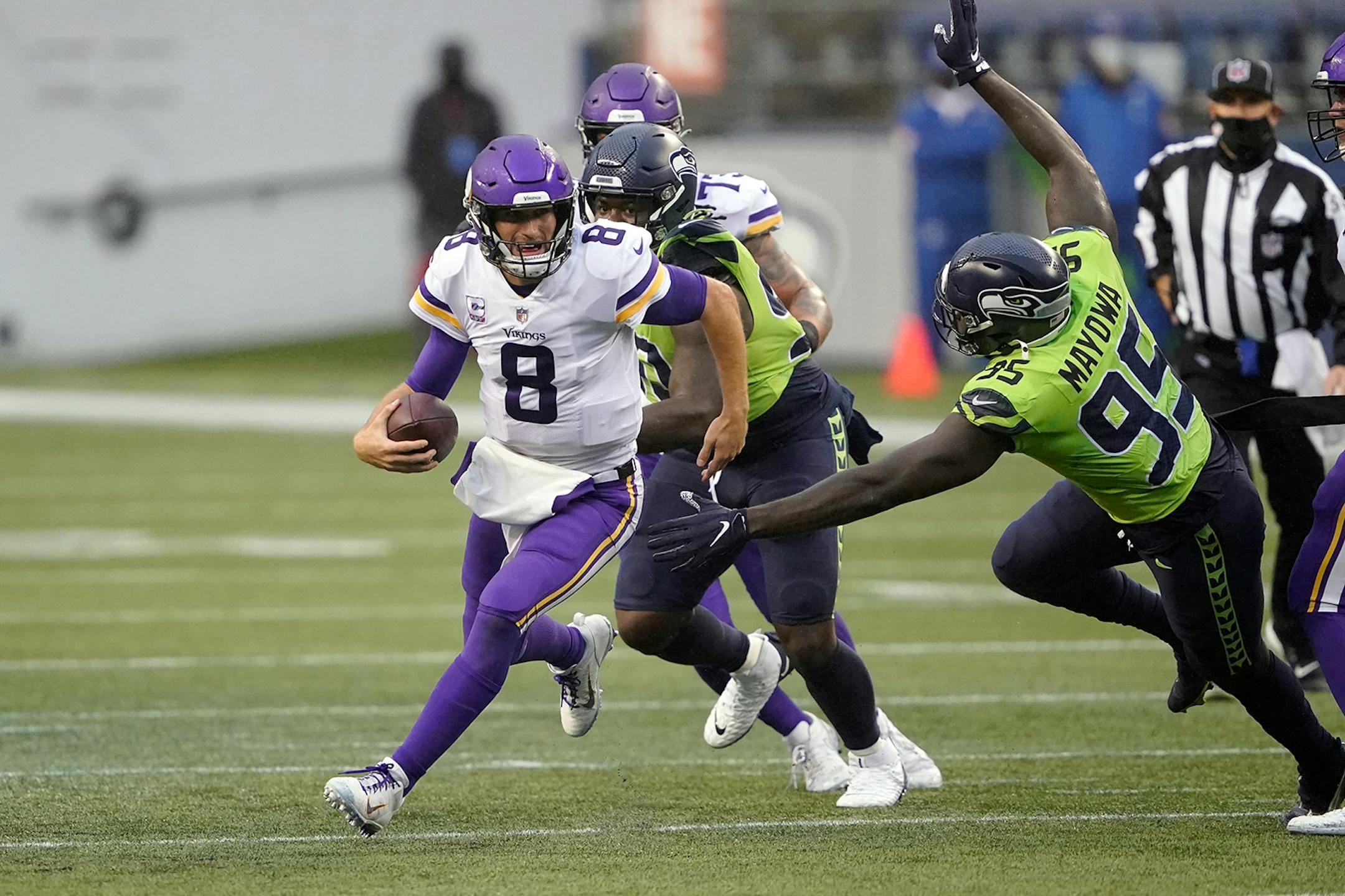 Minnesota Vikings quarterback Kirk Cousins (8) scrambles away from Seattle Seahawks defensive end Benson Mayowa during the first half of an NFL football game, Sunday, Oct. 11, 2020, in Seattle. (AP Photo/Ted S. Warren)