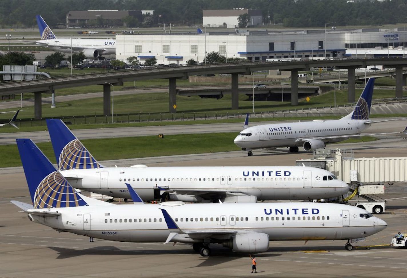 In this July 8, 2015, file photo, a United Airlines plane, front, is pushed back from a gate.