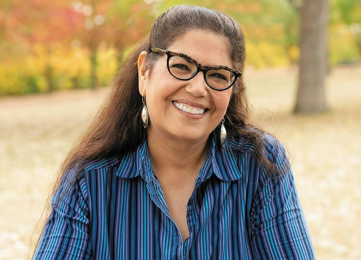 photograph of author Mona Susan Power with backdrop of autumn leaves