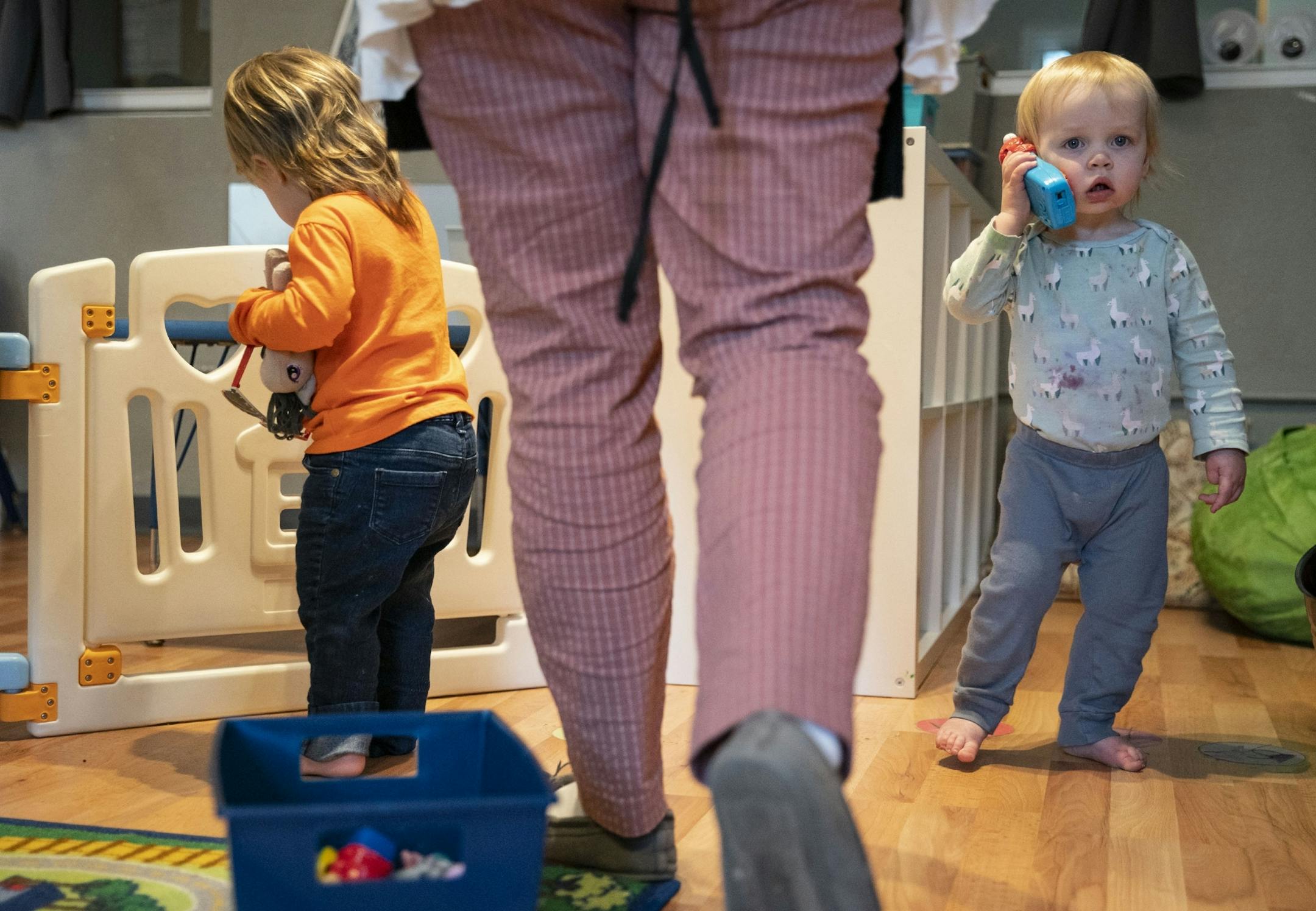 (Left) Charlotte cleaned up toys while Lilly tried to call her mom on a toy phone at Aunty's Child Care in Duluth, MN on Thursday.