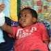 Zion Harvey, 8, of Baltimore, seems to marvel at his new right hand while in his hospital bed on July 27, 2015. Zion lost his hands and feet to a bact