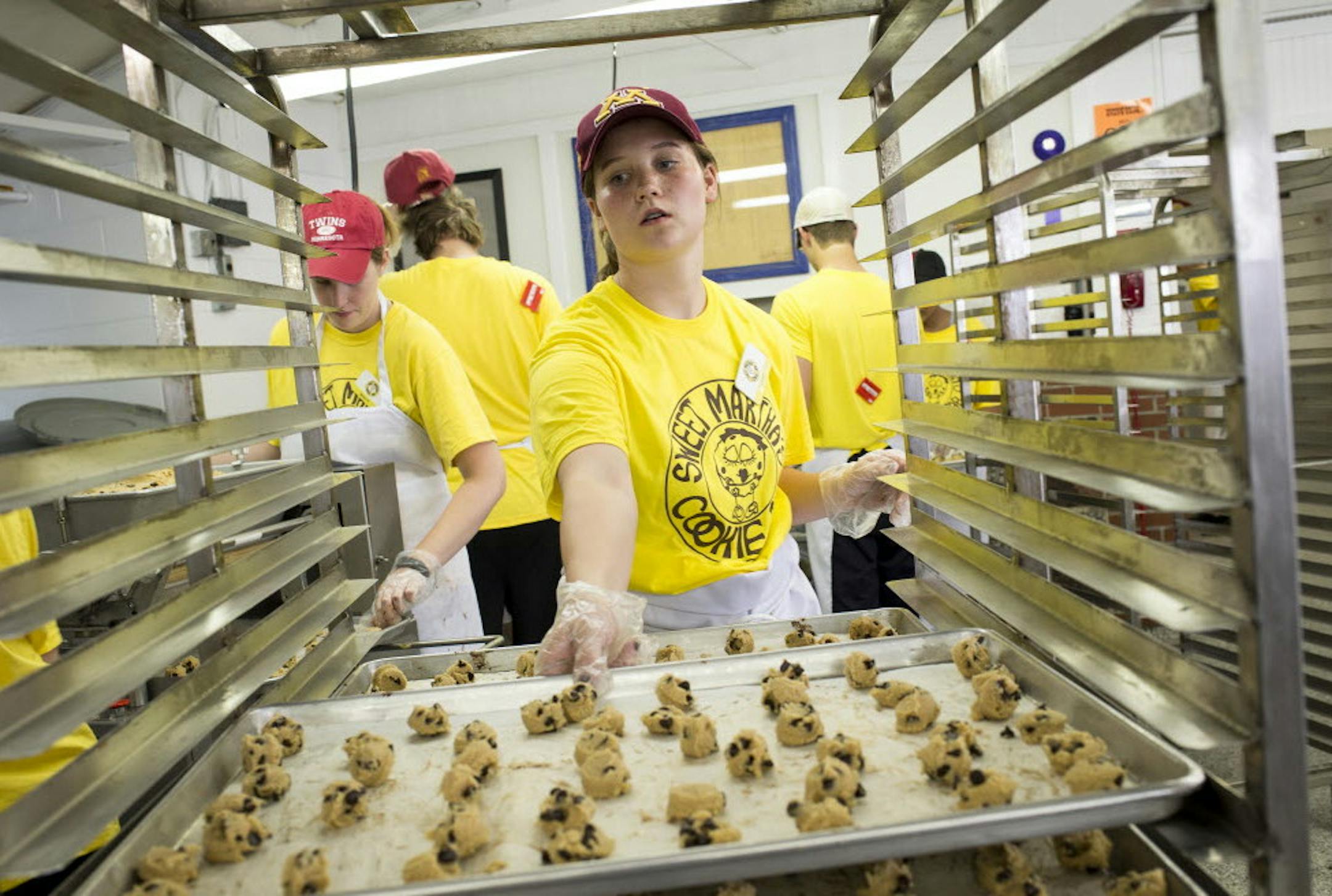 Sweet Martha's Cookie Jar employee Lucie Hoeschen placed a baking sheet with dollops of cookie dough onto a cart before the cart was moved to the oven Thursday. ] Aaron Lavinsky • aaron.lavinsky@startribune.com Behind the scenes at one of the State Fair's most quintessential booths: Sweet Martha's Cookie Jar. Started in 1979 by Martha Olson, the booth has moved and expanded six times, but still can't keep up with the massive lines. Martha estimates they bake and sell 1 million cookies a d