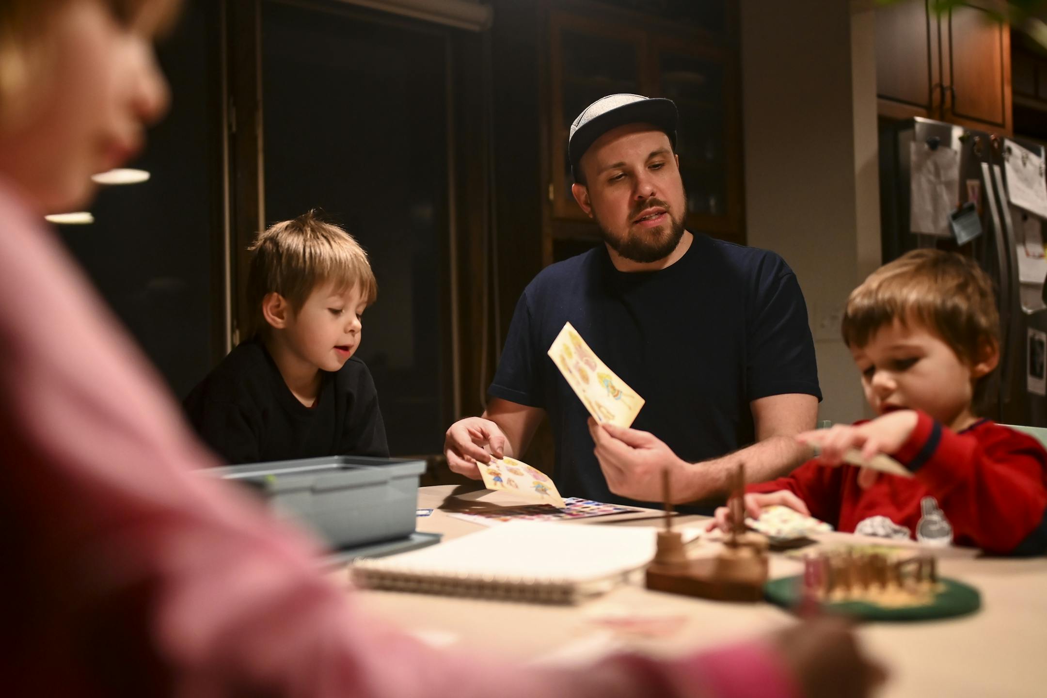 Aaron Mader played a matching game with his three children, from left, Penny, 6, and twin brothers Lou and Cam, 4, Tuesday night.