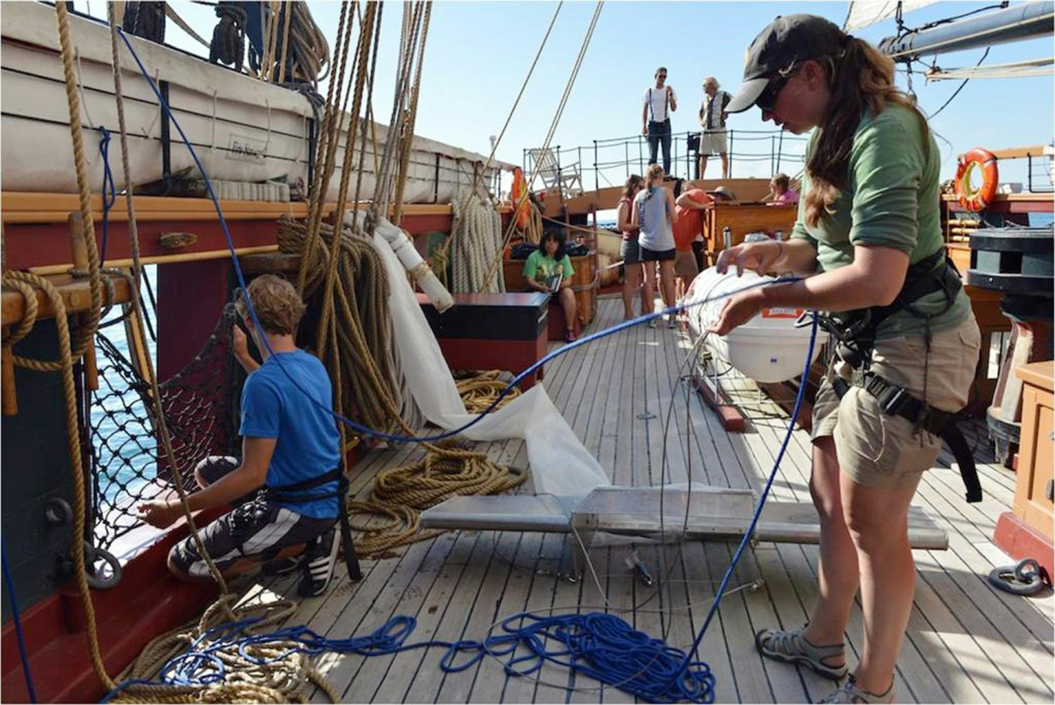 In this 2012 photo provided by 5gyres.org, Sherri Mason, right, a chemist with State University of New York at Fredonia and one of the project leaders, works aboard a research vessel on Lake Erie with a device that skims the water surface collecting samples in finely meshed netting. Scientists discovered masses of floating plastic particles in Lakes Superior, Huron and Erie last year.