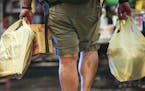 A man carried plastic bags of groceries out of Kowalski's in Uptown in Minneapolis, Minn., on Thursday, July 23, 2015. ] RENEE JONES SCHNEIDER &#x2022