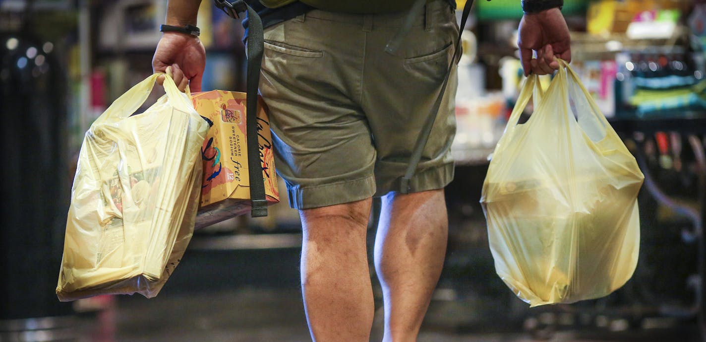 A man carried plastic bags of groceries out of Kowalski's in Uptown in Minneapolis, Minn., on Thursday, July 23, 2015. ] RENEE JONES SCHNEIDER &#x2022; reneejones@startribune.com ORG XMIT: MIN1507232328282045