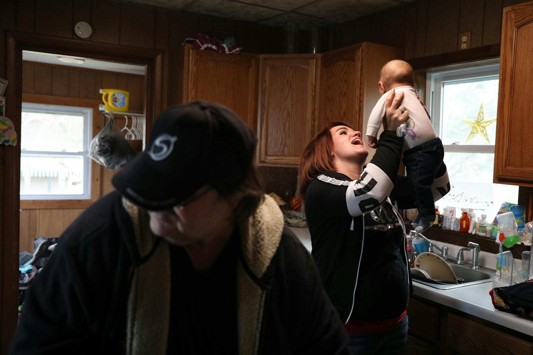 Ashley Benson, a mother of four who went through Sanford Bemidji Medical Center's First Steps program to help pregnant opioid addicts wean off their addictions, played with her son Graysen Burnette, 4-months, as her uncle Bob Benson made dinner at their home.