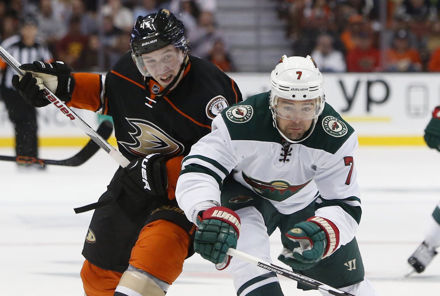 Anaheim Ducks Sami Vatanen, left, and Minnesota Wild's Chris Porter battle for the puck in the first period of an NHL hockey game in Anaheim, Calif., Sunday, Oct.18, 2015. (AP Photo/Christine Cotter)