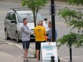 People engaging in casual conversation on a sidewalk in Owen Sound, Ontario, Canada.