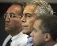 FILE - In this July 30, 2008, file photo, Jeffrey Epstein, center, appears in court in West Palm Beach, Fla. At the center of Epstein's secluded New M