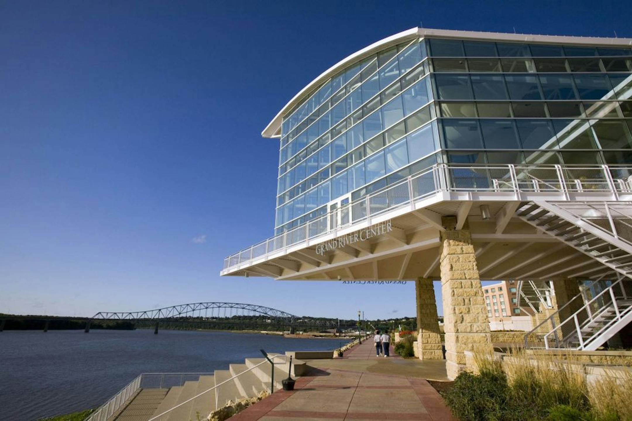 Visitors stroll the Riverwalk in the revitalized Port of Dubuque, where the Grand River Center stands as one of the focal points along the Mississippi River.