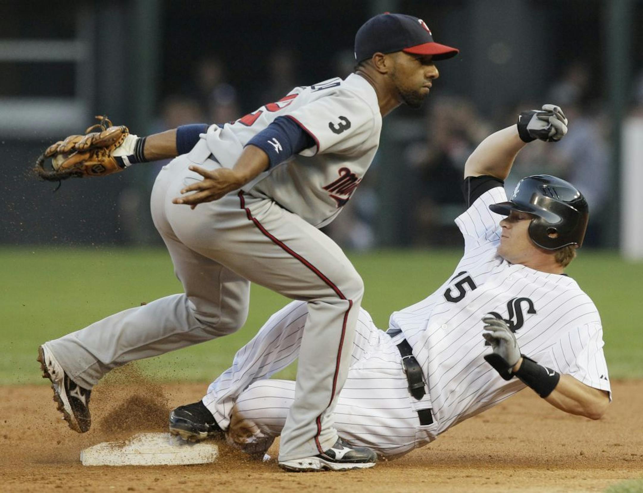 Chicago White Sox's Gordon Beckham, right, slides safely into second as Minnesota Twins second baseman Alexi Casilla applies a late tag during the first inning of a baseball game Friday, July 8, 2011, in Chicago.