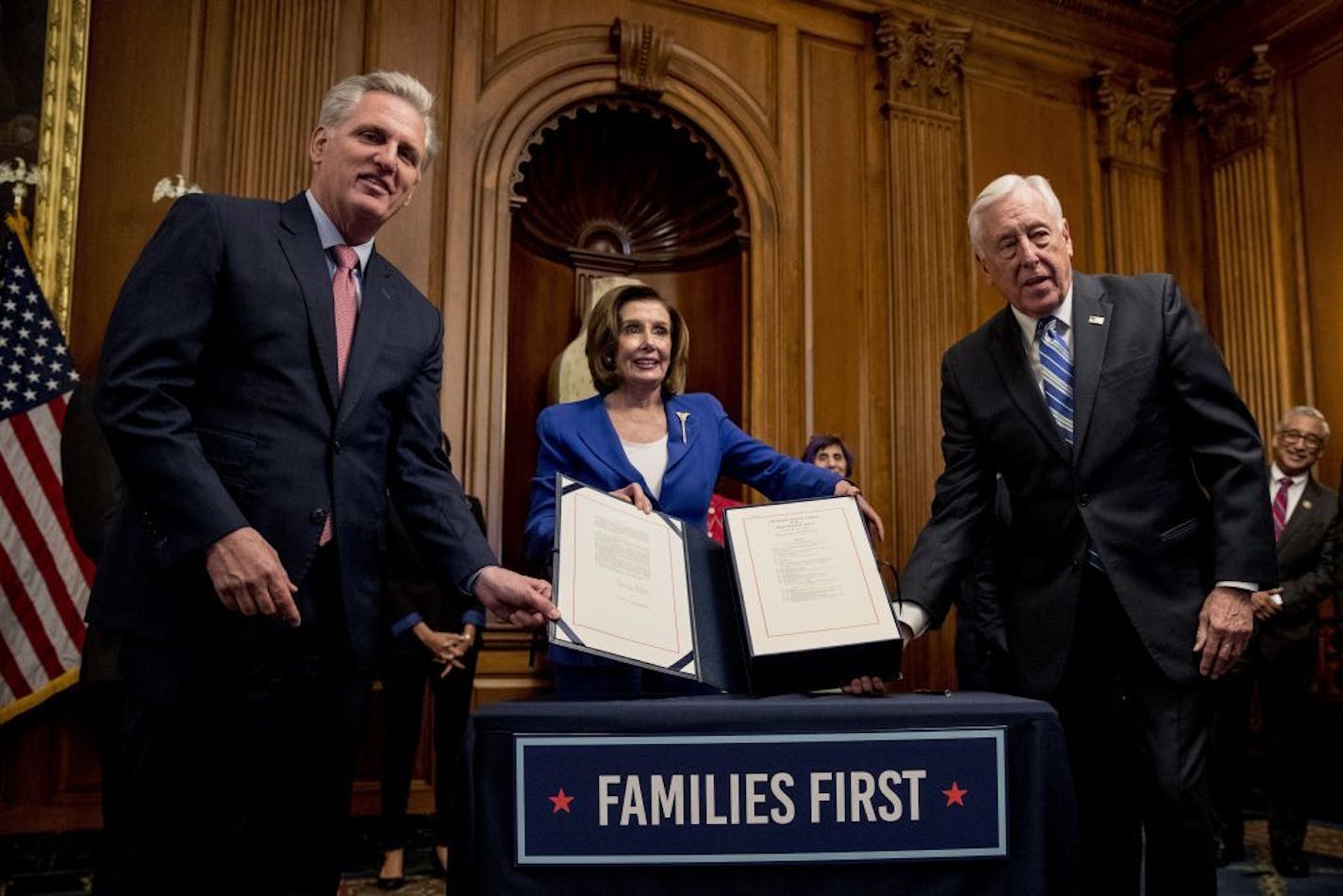 House Speaker Nancy Pelosi of Calif., House Minority Leader Kevin McCarthy of Calif., left, and House Majority Leader Steny Hoyer of Md., right, holds up the Coronavirus Aid, Relief, and Economic Security (CARES) Act after Pelosi signed it on Capitol Hill, Friday, March 27, 2020, in Washington. The $2.2 trillion package will head to head to President Donald Trump for his signature.