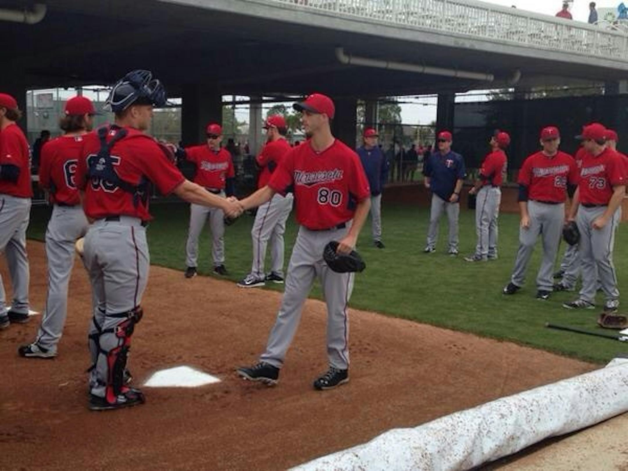 Catcher Stuart Turner shakes hands with pitcher Taylor Rogers during communications exercise in Twins' bullpen on Friday.