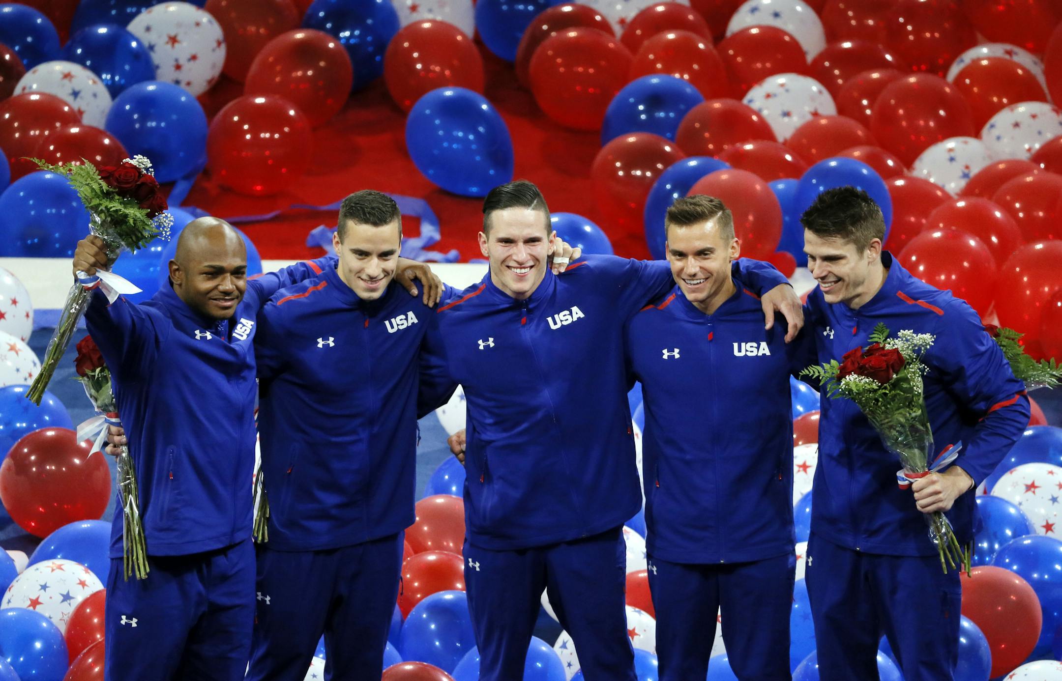 Sam Mikulak, from left, Alex Naddour, Chris Brooks, Jacob Dalton and John Orozco, right, acknowledge cheers from fans after being introduced as the U.S. men's Olympic gymnastics team, Saturday, June 25, 2016, in St. Louis. (AP Photo/Tony Gutierrez)