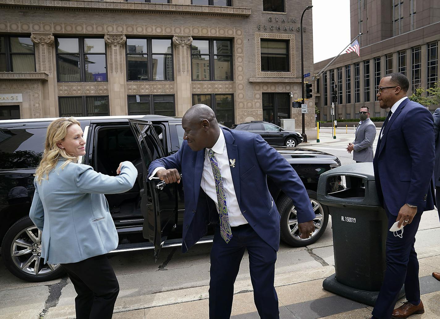 Attorney Ben Crump, who represents George Floyd's family, announced in a press conference that the family of Floyd is suing the city of Minneapolis and the four officers involved in his death, citing a failure in proper police training and a racist departmental culture that led to a "reckless disregard" of Floyd's civil rights Wednesday outside the US Federal Courthouse in Minneapolis. Here, Crump, center, gets an elbow bump from a member of his legal team representing the Floyd family.] DAVID J