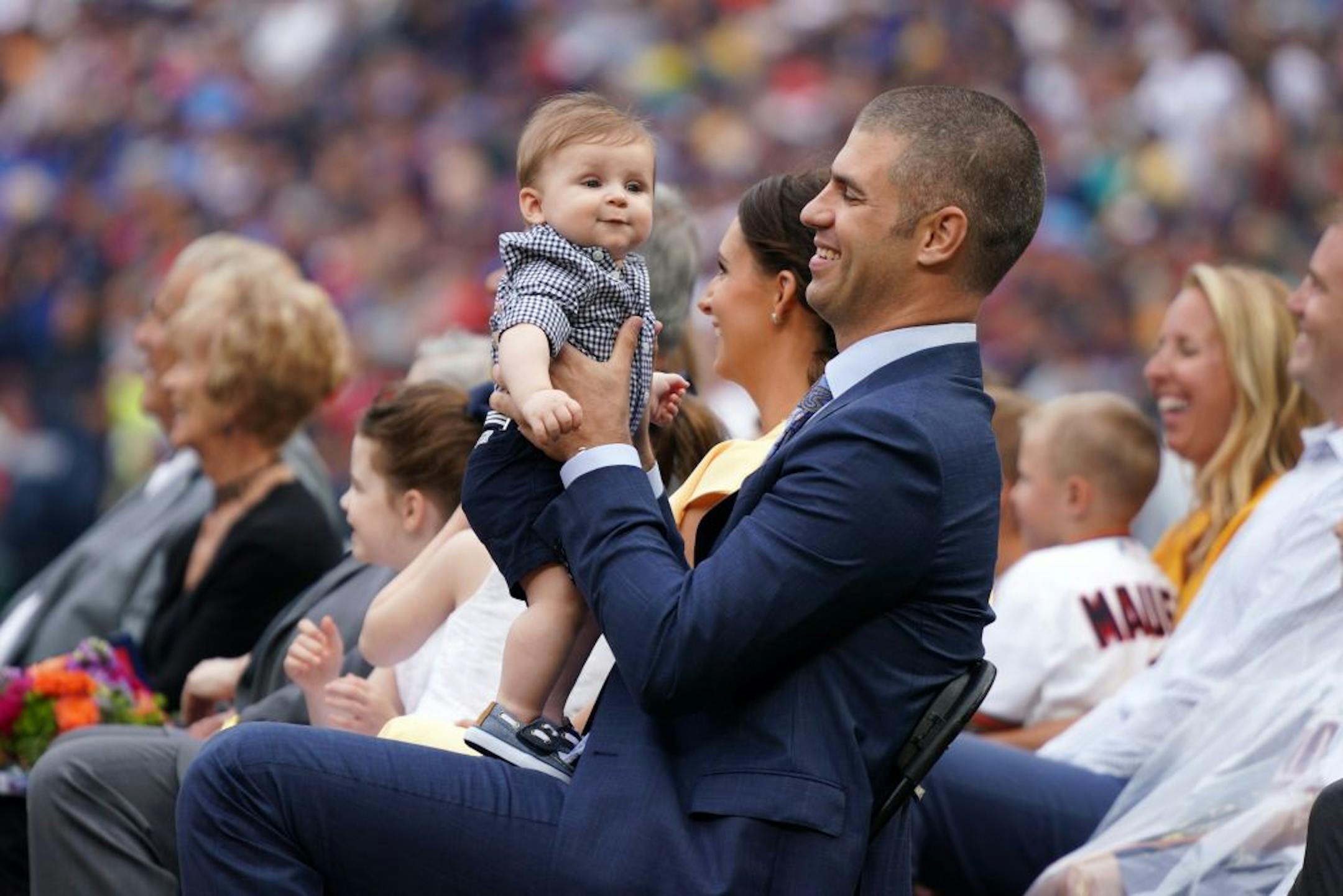 Former Twins great Joe Mauer held his son Charles during a pregame ceremony to retire his number 7 Saturday.