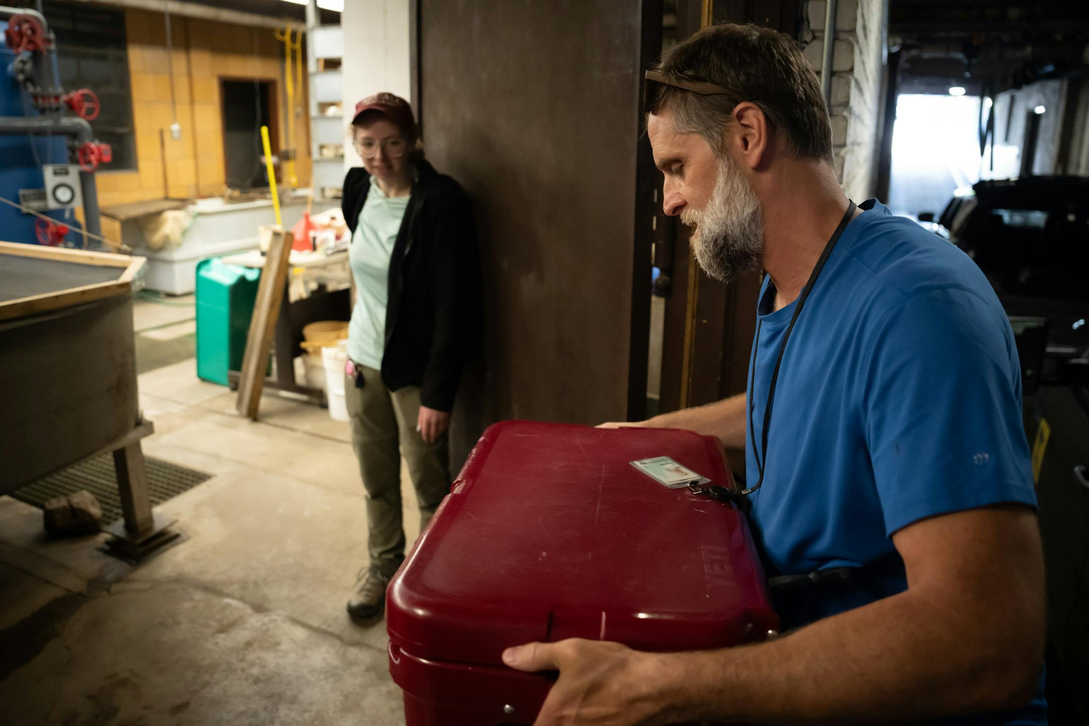 Genevieve Furtner, St. Paul State Fish Hatchery Supervisor, held the door as East Metro Supervisor T.J. DeBates carried in a cooler of donated aquarium fish.