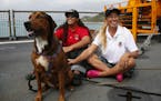 Jennifer Appel, right, and Tasha Fuiava sit with one of their dogs on the deck of the USS Ashland Monday, Oct. 30, 2017, at White Beach Naval Facility