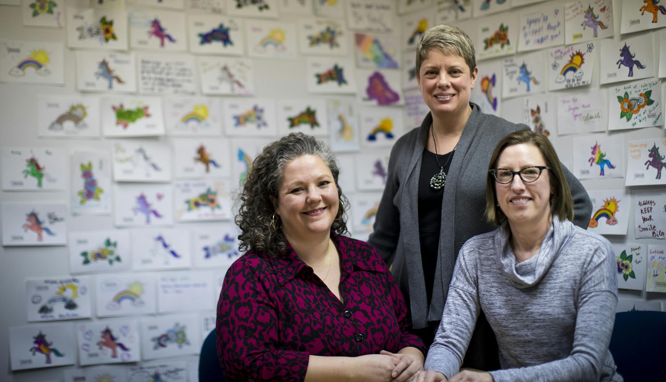 Gender Justice&#x2019;s Megan Peterson, left, Jill Gaulding, center, and Lisa Stratton in front of a wall filled with messages for transgender youth.