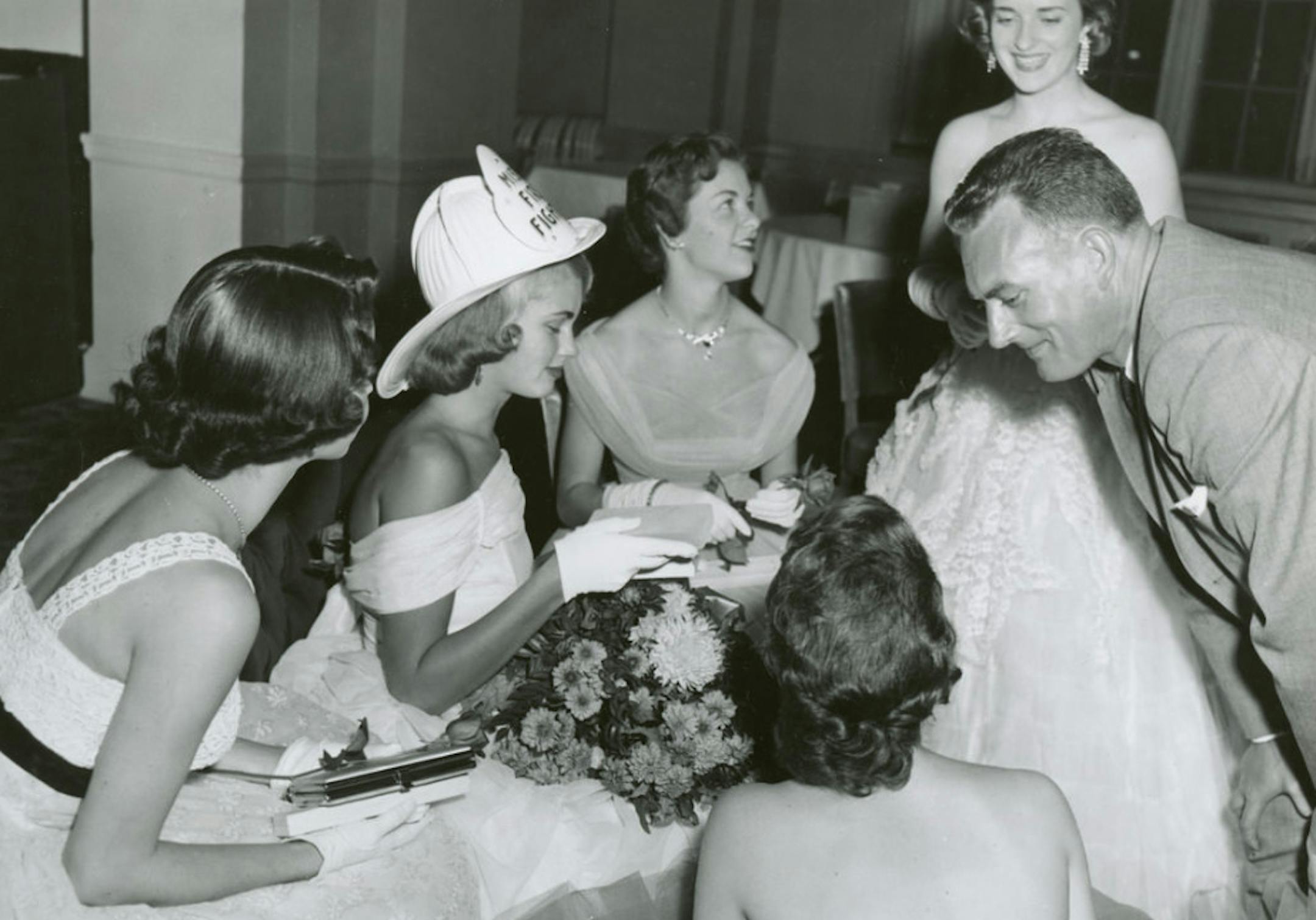 New 1958 Miss Firefighter receiving gift and flowers. ca. 1957 credit: City of MInneapolis archives