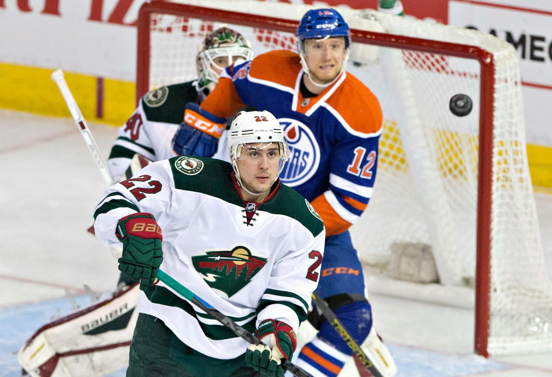 Minnesota Wild's Nino Niederreiter (22) and goalie Devan Dubnyk (40) and Edmonton Oilers' Rob Klinkhammer (12) look for the loose puck during the second period of an NHL hockey game Friday, Feb. 20, 2015, in Edmonton, Alberta. (AP Photo/The Canadian Press, Jason Franson)