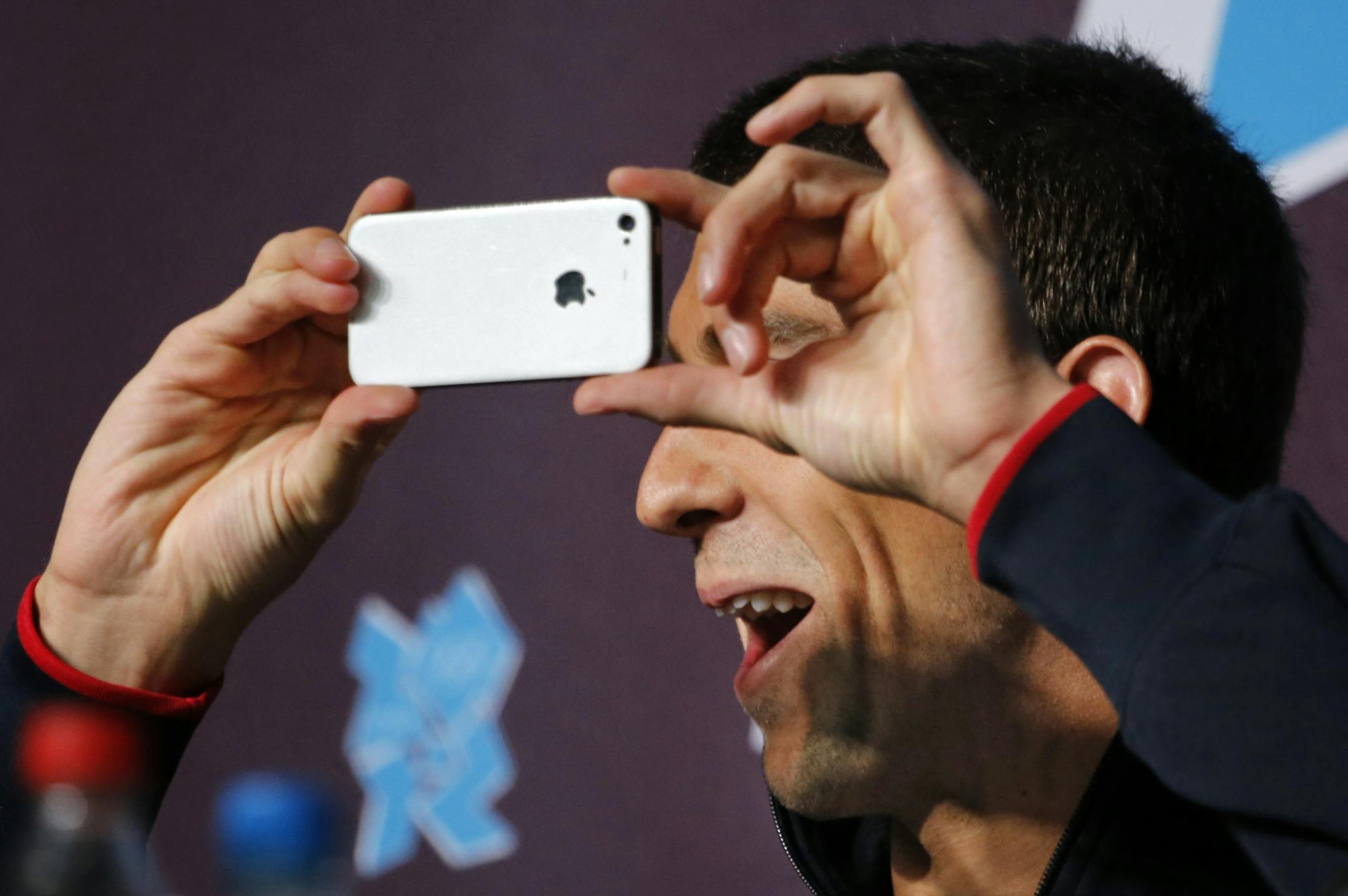 Michael Phelps joined his Team USA teammates in a pre-Olympics press conference Thursday, pulling out his iPhone at one point to take a picture of the hundreds of reporters who had gathered to ask questions.