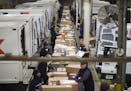 FILE - In this Dec. 14, 2014 file photo, packages are sorted on a conveyer belt before being loaded onto trucks for delivery at a FedEx facility in Ma