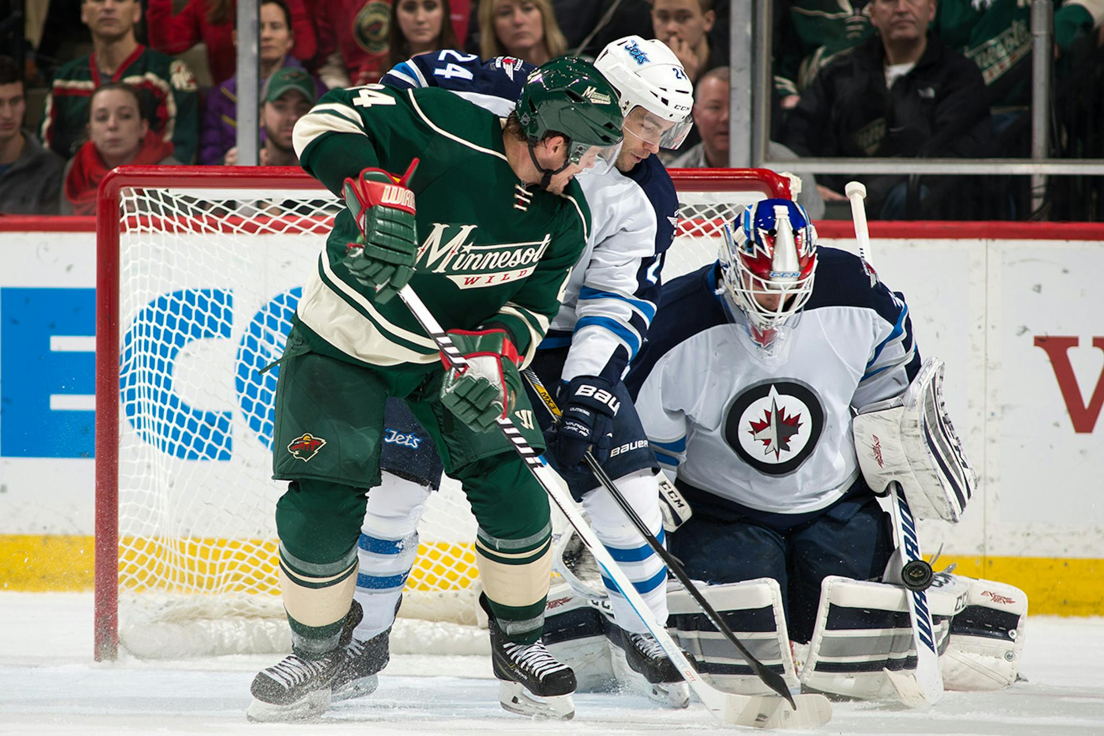Minnesota Wild left wing Matt Cooke (24) tries a backhanded shot but is stopped by Winnipeg Jets goalie Michael Hutchinson (34) during the third period.