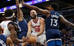 Dec 28, 2021; Minneapolis, Minnesota, USA; New York Knicks guard Evan Fournier (13) works between Minnesota Timberwolves forward Jaden McDaniels (3) a