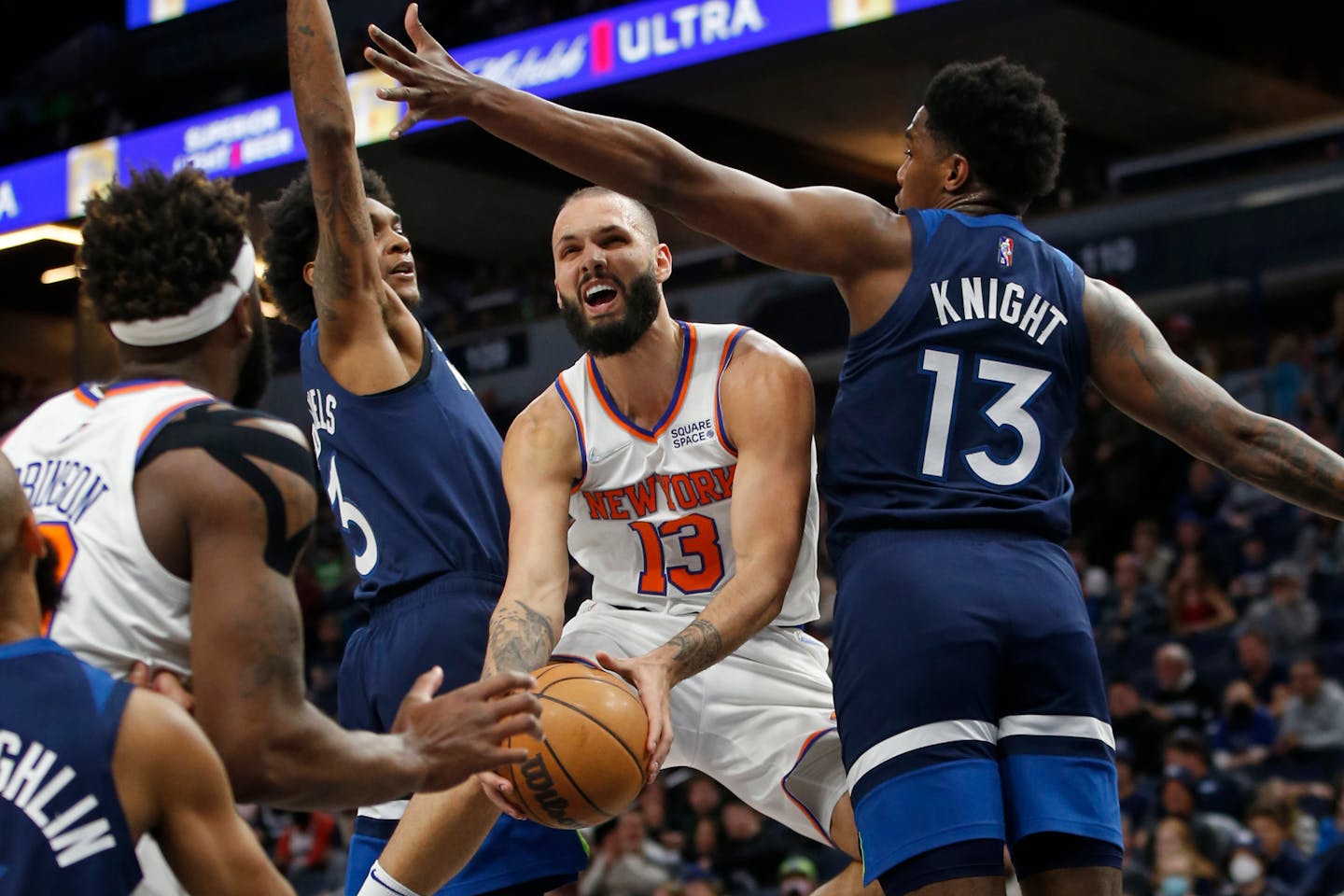 Dec 28, 2021; Minneapolis, Minnesota, USA; New York Knicks guard Evan Fournier (13) works between Minnesota Timberwolves forward Jaden McDaniels (3) and forward Nathan Knight (13) to shoot the ball in the first quarter at Target Center. Mandatory Credit: Bruce Kluckhohn-USA TODAY Sports