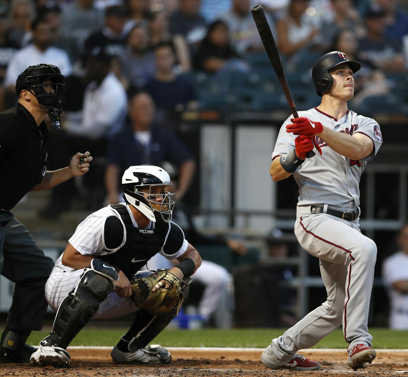 Minnesota Twins' Max Kepler, right, hits a three run home run during second inning of a baseball game as Chicago White Sox catcher James McCann, center, and home plate umpire Chris Segal, left, look on Friday, July 26, 2019, in Chicago. (AP Photo/Jeff Haynes)