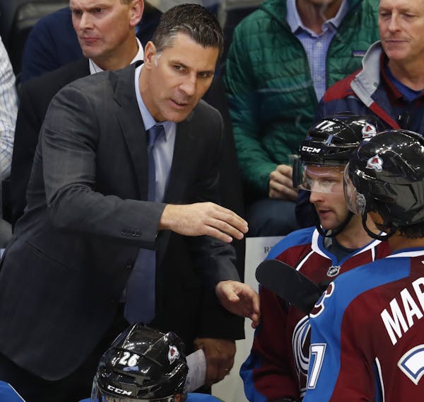 Colorado Avalanche head coach Jared Bednar, left, directs right wing Mike Sislo, center, and left wing Andreas Martinsen as they come off the ice from