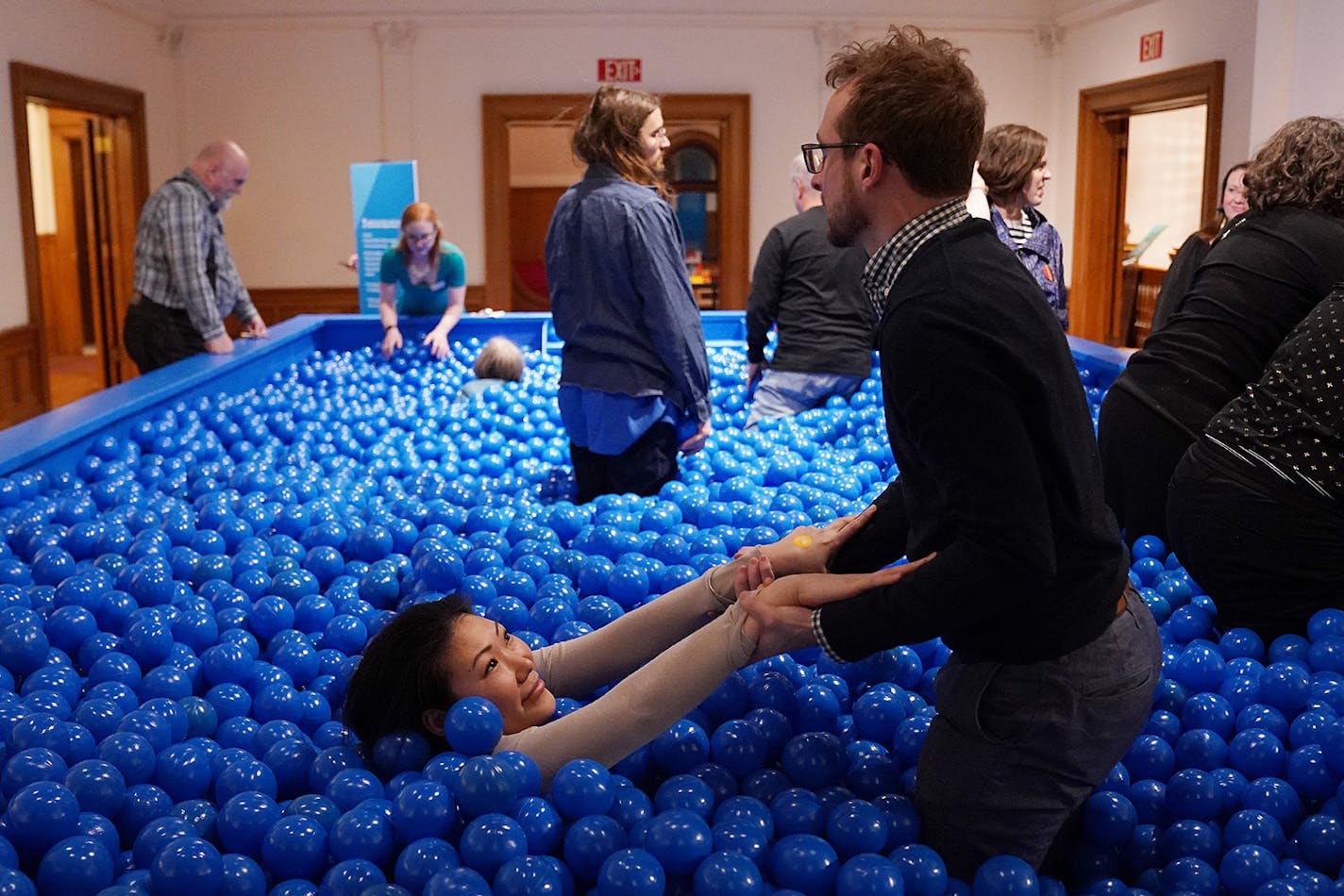 Emma Olstad got a helping hand from her partner John Pilla as they and fellow guests played in the interactive ball pit exhibit set up in the American Swedish Institute's ballroom.