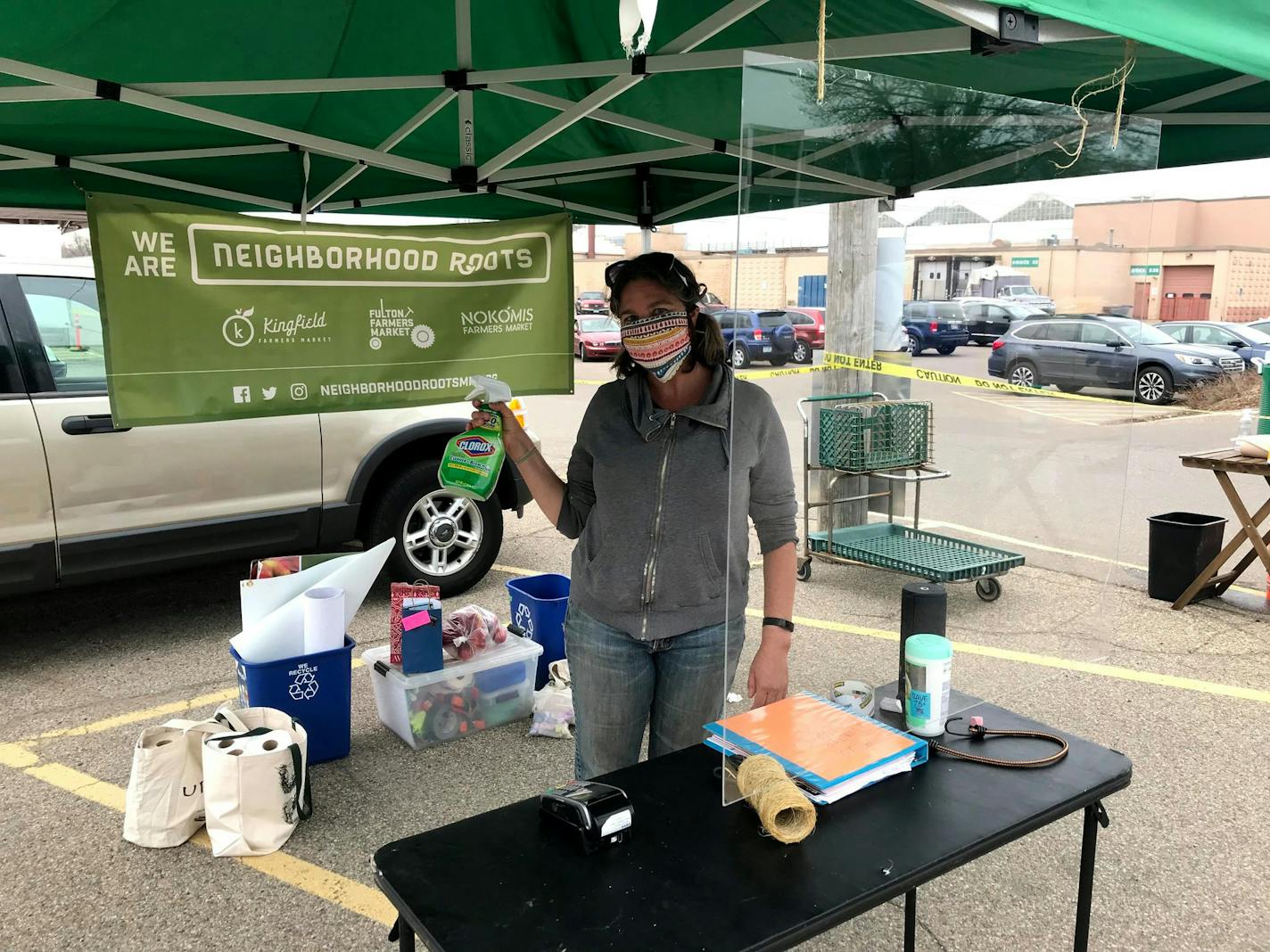 Safety first! Neighborhood Roots Farmers Market stocked up on cleaning supplies, made some cool masks and installed a plexiglass screen at their info tent.