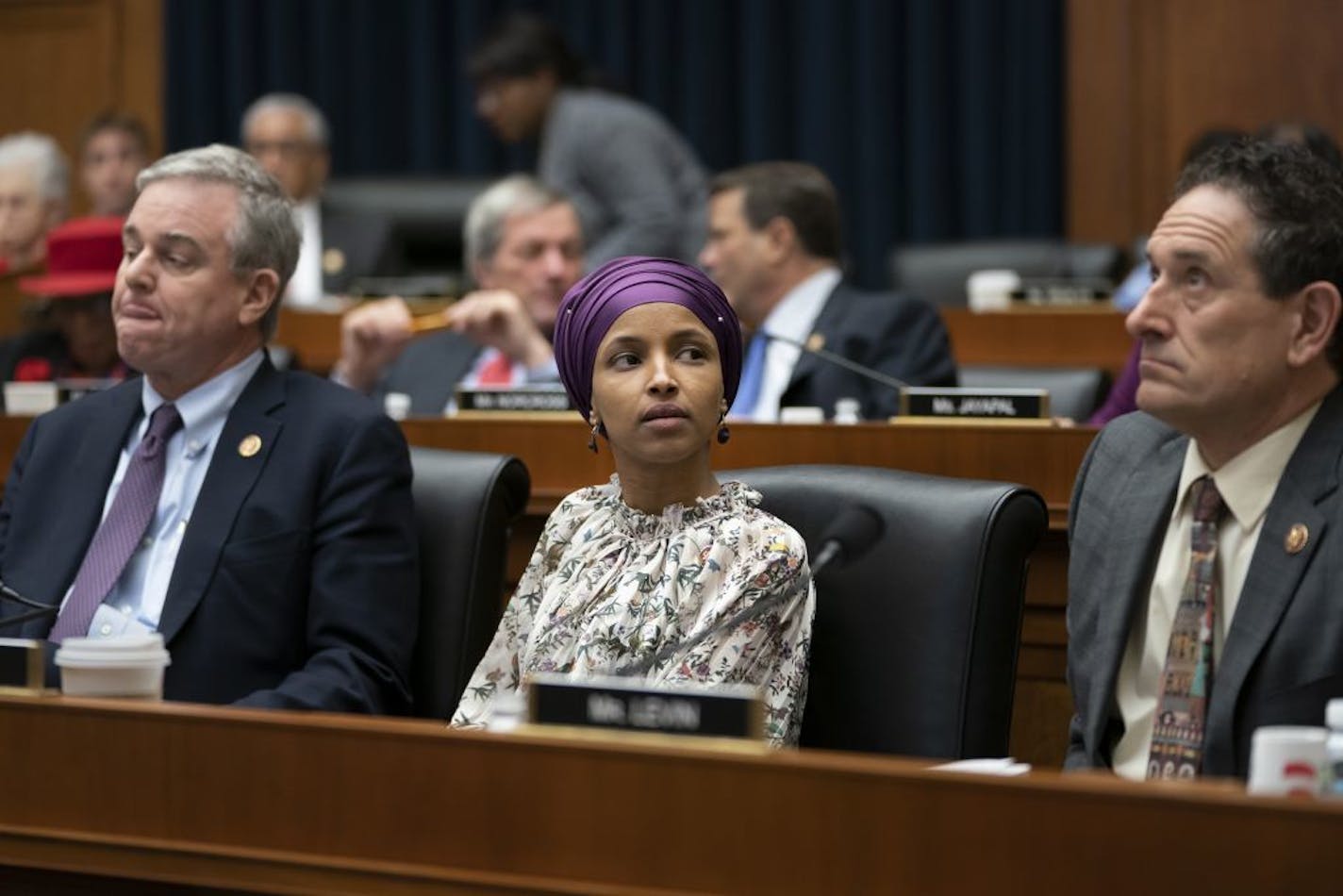 Rep. Ilhan Omar, D-Minn., sits with fellow Democrats David Trone of Maryland, left, and Andy Levin, of Michigan, right, at a session of the House Education and Labor Committee on Wednesday.