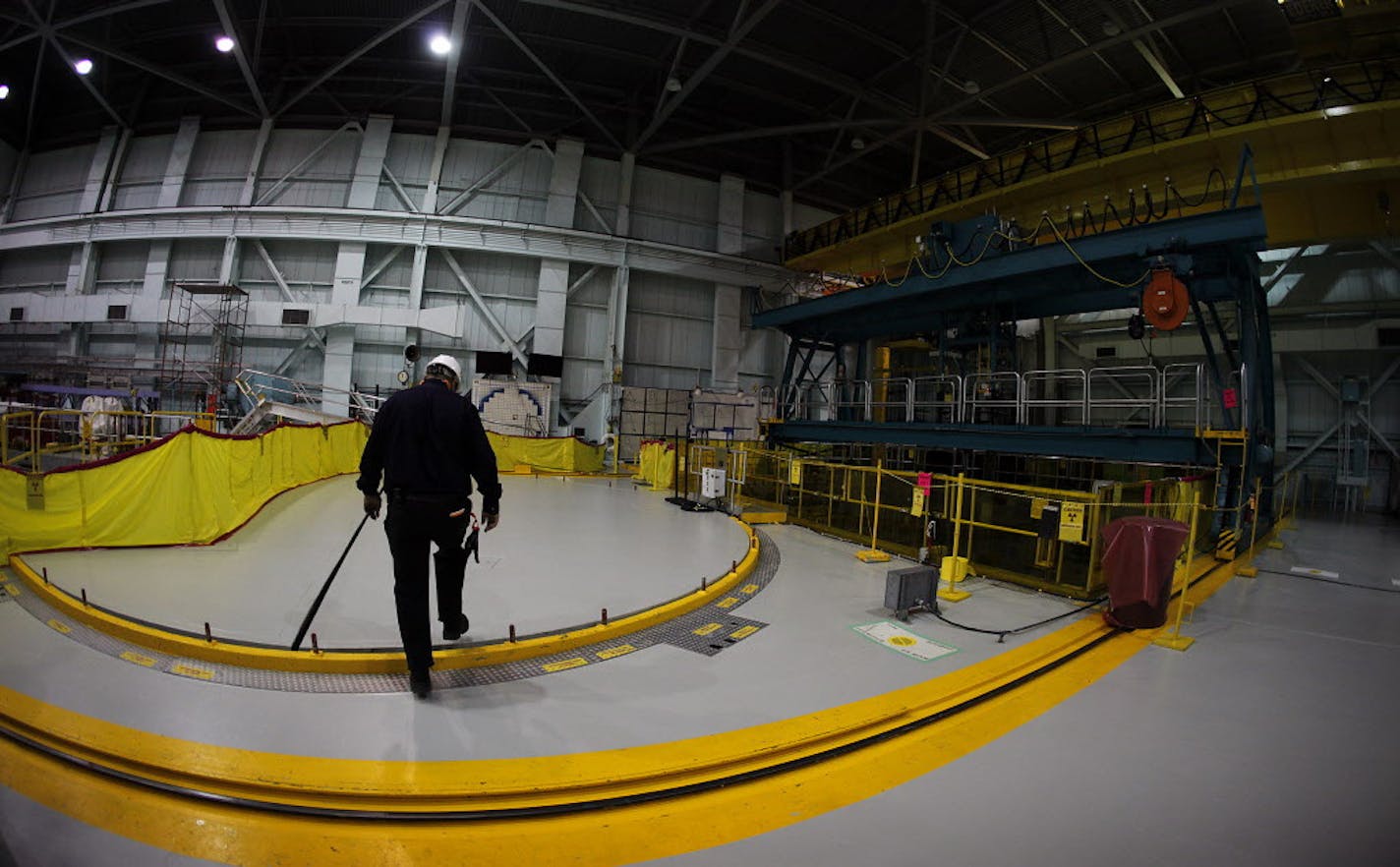 Xcel Energy nuclear engineer Jeff Davis steps atop a bolted-down steel plate at the top of the Monticello nuclear power plant. At right is a 38-feet-deep pool in which spent fuel rods taken out of the reactor simmer for about a decade before they are moved to casks that are stored outdoors. The plant is a boiling water reactor similar those damaged in the March 2011 Fukushima disaster. At three of the Japanese plants, this is part of the building that exploded because hydrogen gas was produced i