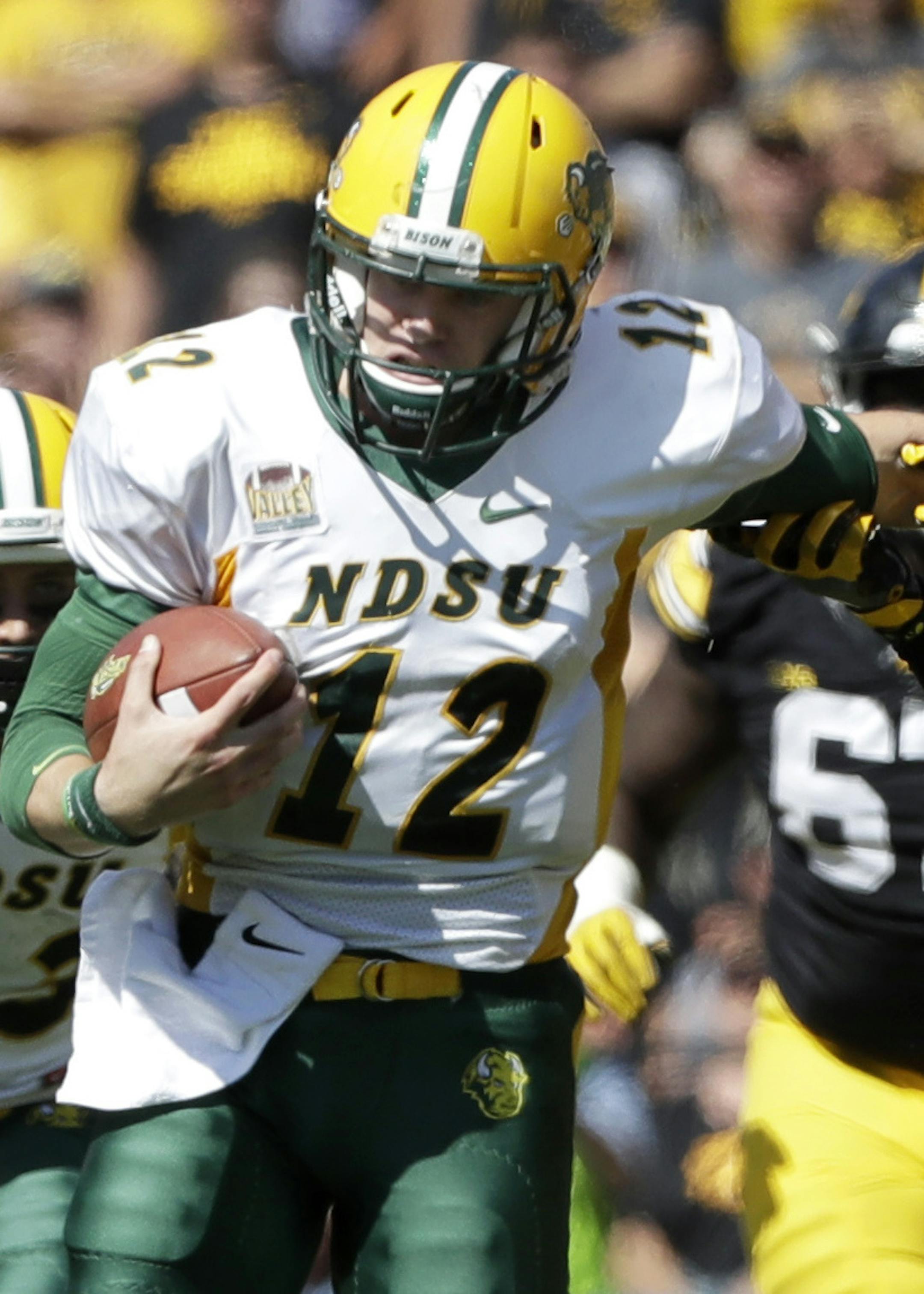 North Dakota State quarterback Easton Stick (12) tries to break a tackle by Iowa defensive back Desmond King, right, during the second half of an NCAA college football game, Saturday, Sept. 17, 2016, in Iowa City, Iowa. North Dakota State won 23-21. (AP Photo/Charlie Neibergall) ORG XMIT: IACN110
