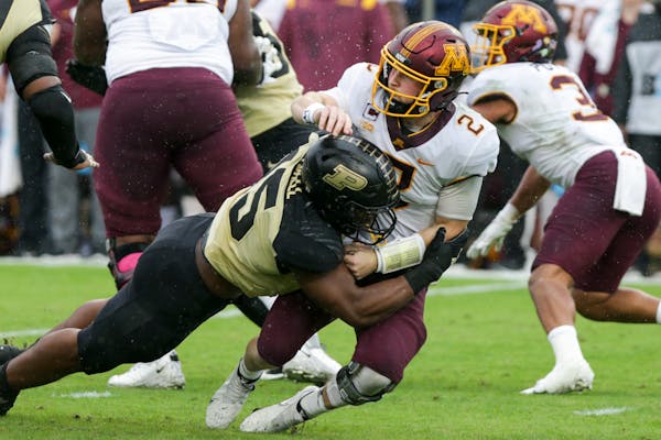 Purdue defensive end George Karlaftis (5) tackles Minnesota quarterback Tanner Morgan (2) during the first quarter of an NCAA college football game, S