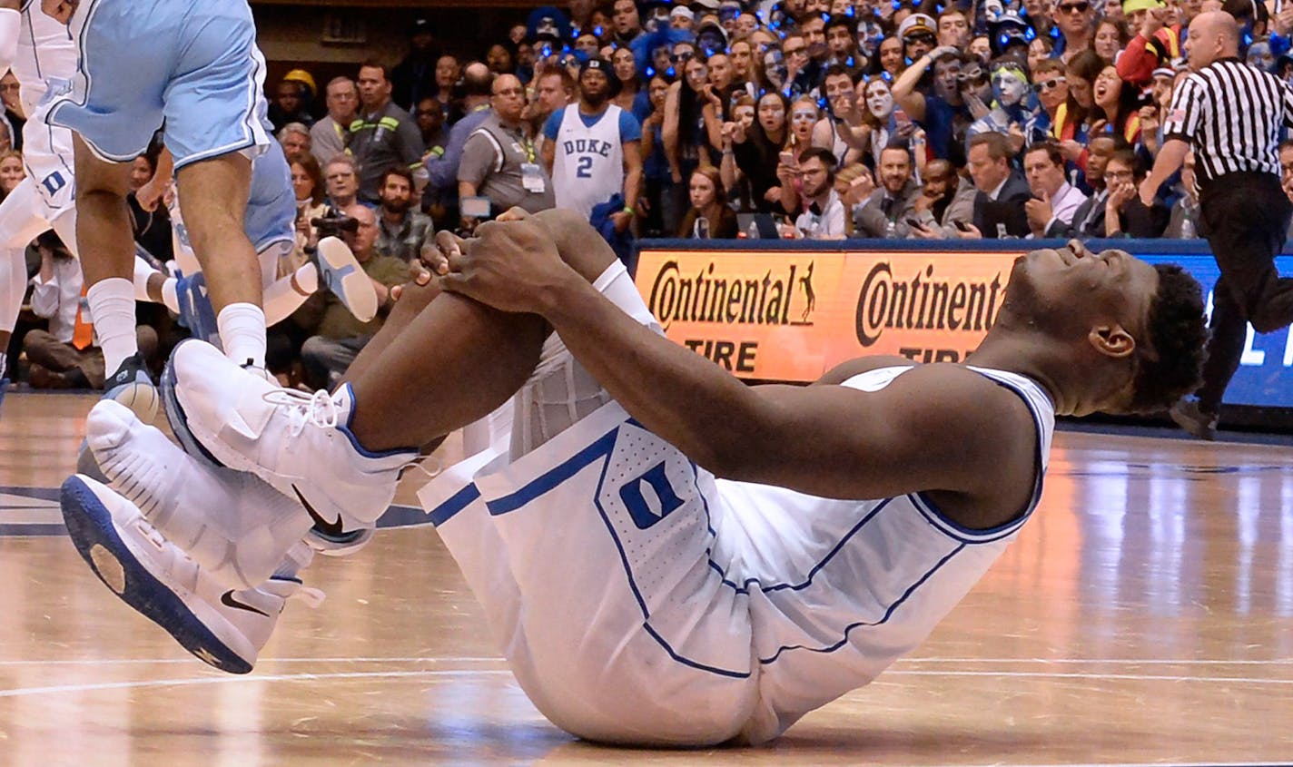 Duke forward Zion Williamson holds his knee after injuring himself and damaging his shoe during the opening moments of the game in the first half on Wednesday, Feb. 20, 2019, at Cameron Indoor Stadium in Durham, N.C. (Chuck Liddy/Raleigh News & Observer/TNS)