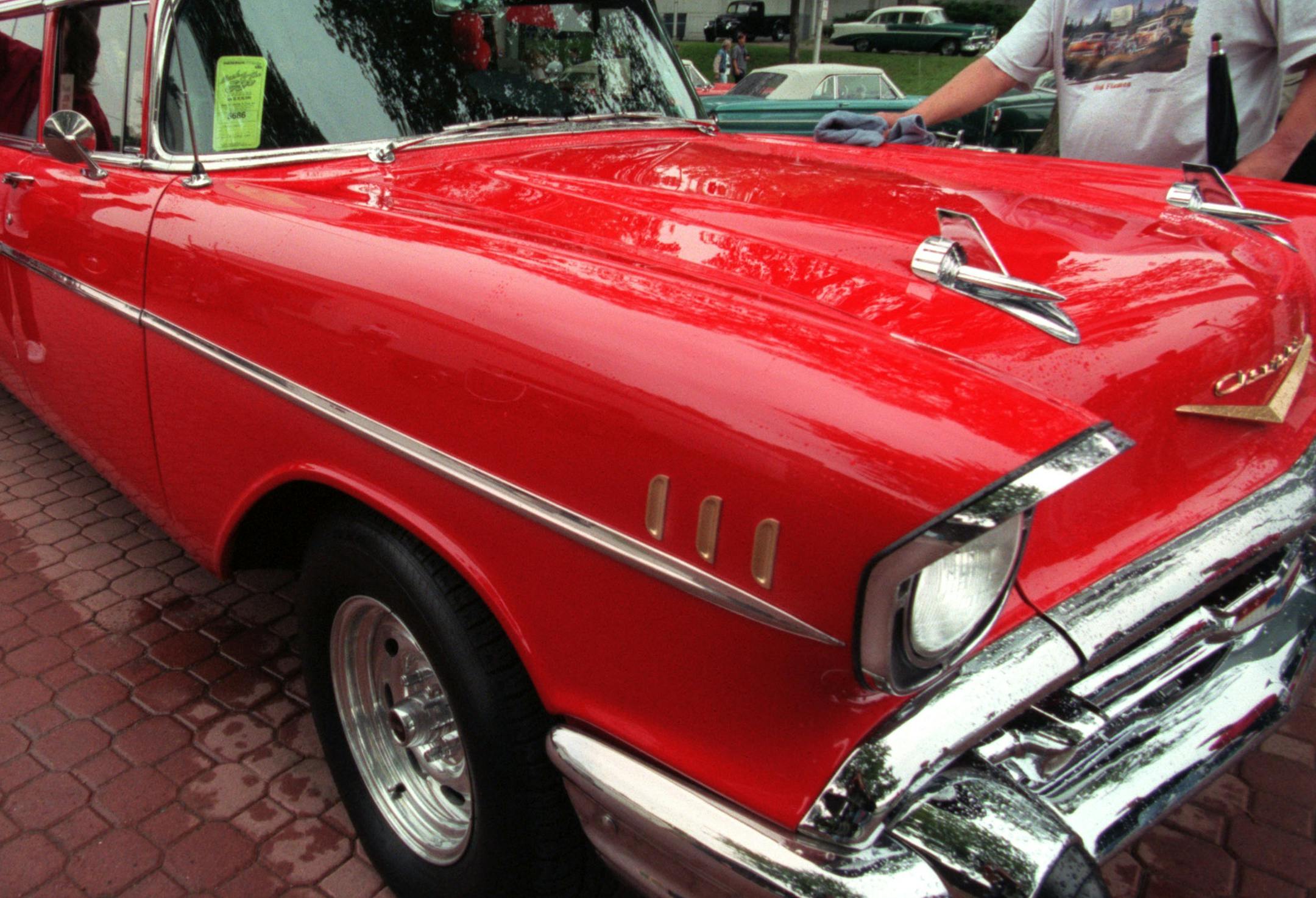 Back to the Ï50s Weekend sponsored- custom, classic and restored vehicles from 1964 and older. -- For the fourth time Saturday, (left to right) Amy Weinmeyer and Dave Gawboy dry off Kurt and Al JoscherÌs Î57 Chevy. The Joscher brothers turned the four-door Belair into a 10-passenger limousine. Weinmeyer is Kurt JoscherÌs fiancee. They are from Burnsville. Gawboy is a friend and lives in Lakeville. The on aagain, off again rain kept the squeegee and towel busy.