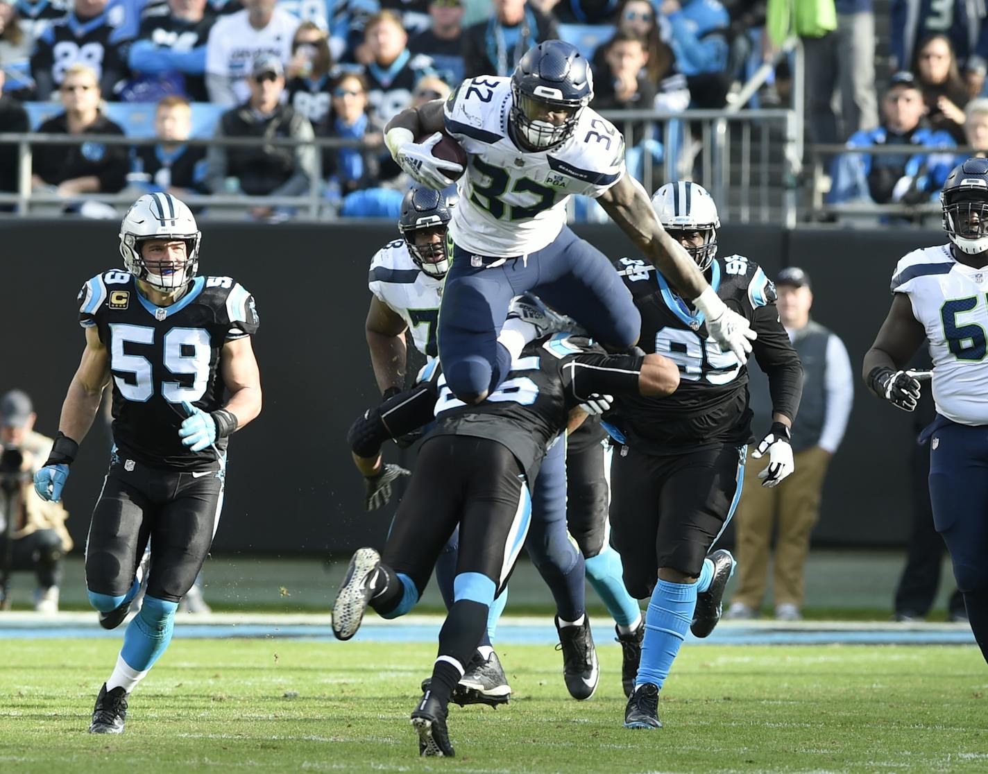 Seattle Seahawks' Chris Carson (32) leaps over Carolina Panthers' Eric Reid (25) during the second half of an NFL football game in Charlotte, N.C., Sunday, Nov. 25, 2018. (AP Photo/Mike McCarn) ORG XMIT: NCCB1