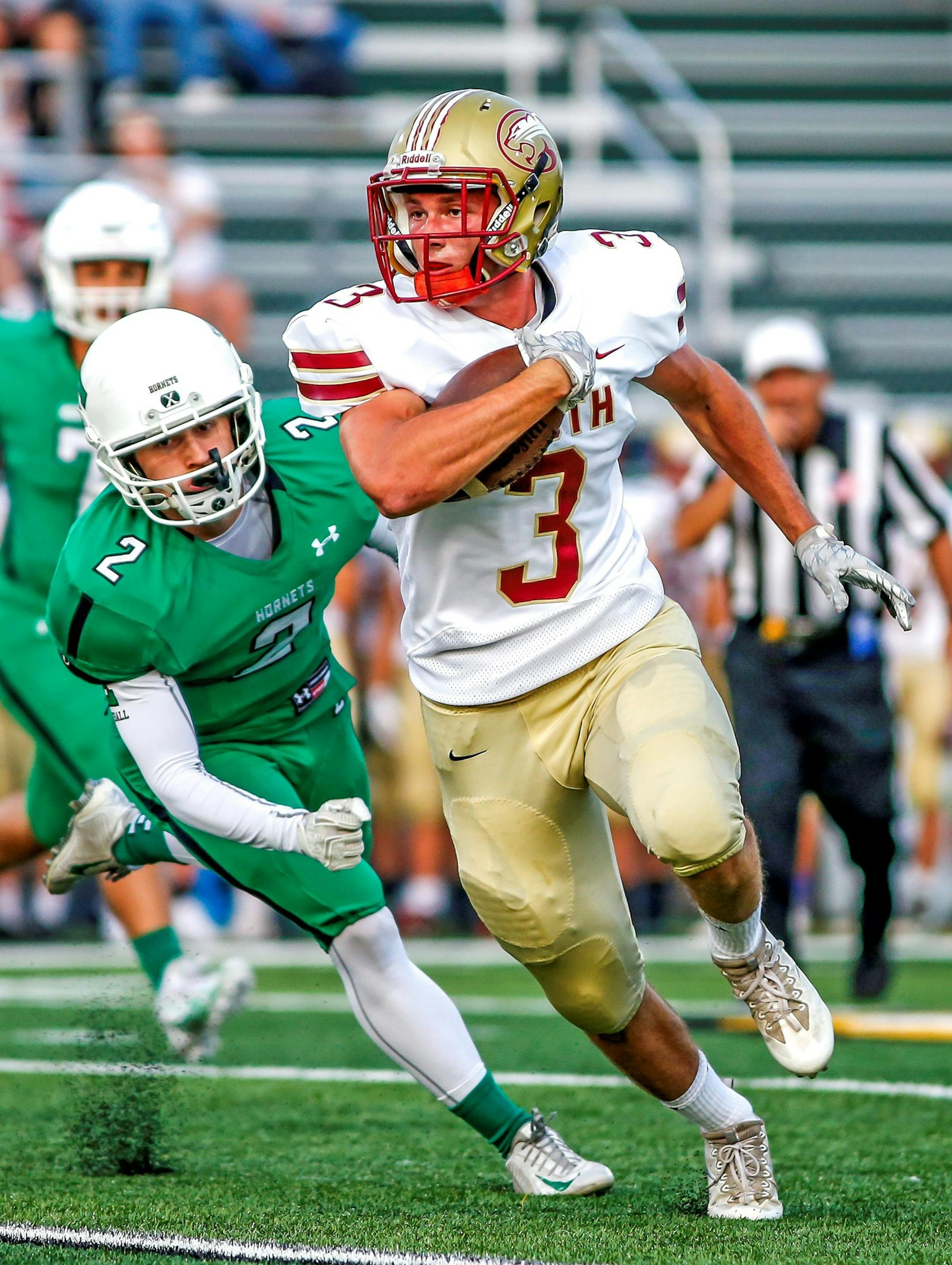 Lakeville South running back Jeremiah Jacobson (3) gets around Edina defender Nick Pugliese (2) on his way to a 26-yard first-quarter gain that set up a field goal and pulled the Cougars within 7-3 of Edina. Lakeville South at Edina football, 8-31-17. Photo by Mark Hvidsten, SportsEngine