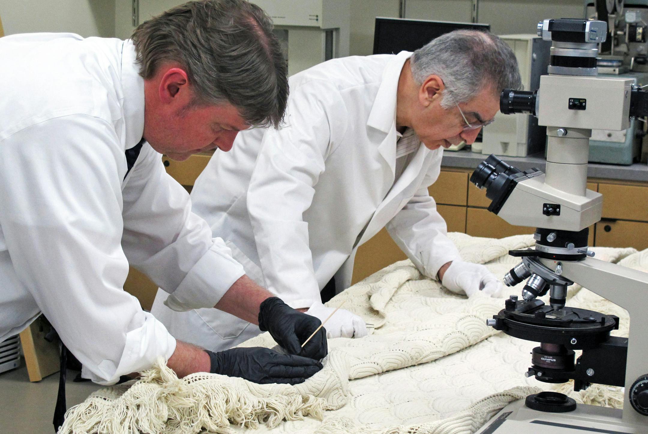 Daniel J. Campbell, left, forensic scientist supervisor-DNA at the Wisconsin State Crime Lab, swabs for possible blood stains as University of Wisconsin-Madison professor of textile science Majid Sarmadi examines a cotton bedspread that may have come from Abraham Lincoln's death bed, on March 31, 2015, in Madison, Wis. (Meg Jones/Milwaukee Journal Sentinel/TNS)
