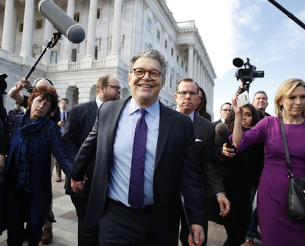 Sen. Al Franken, D-Minn., center, holds hands with his wife Franni Bryson, as he leaves the Capitol after speaking on the Senate floor, Thursday, Dec.