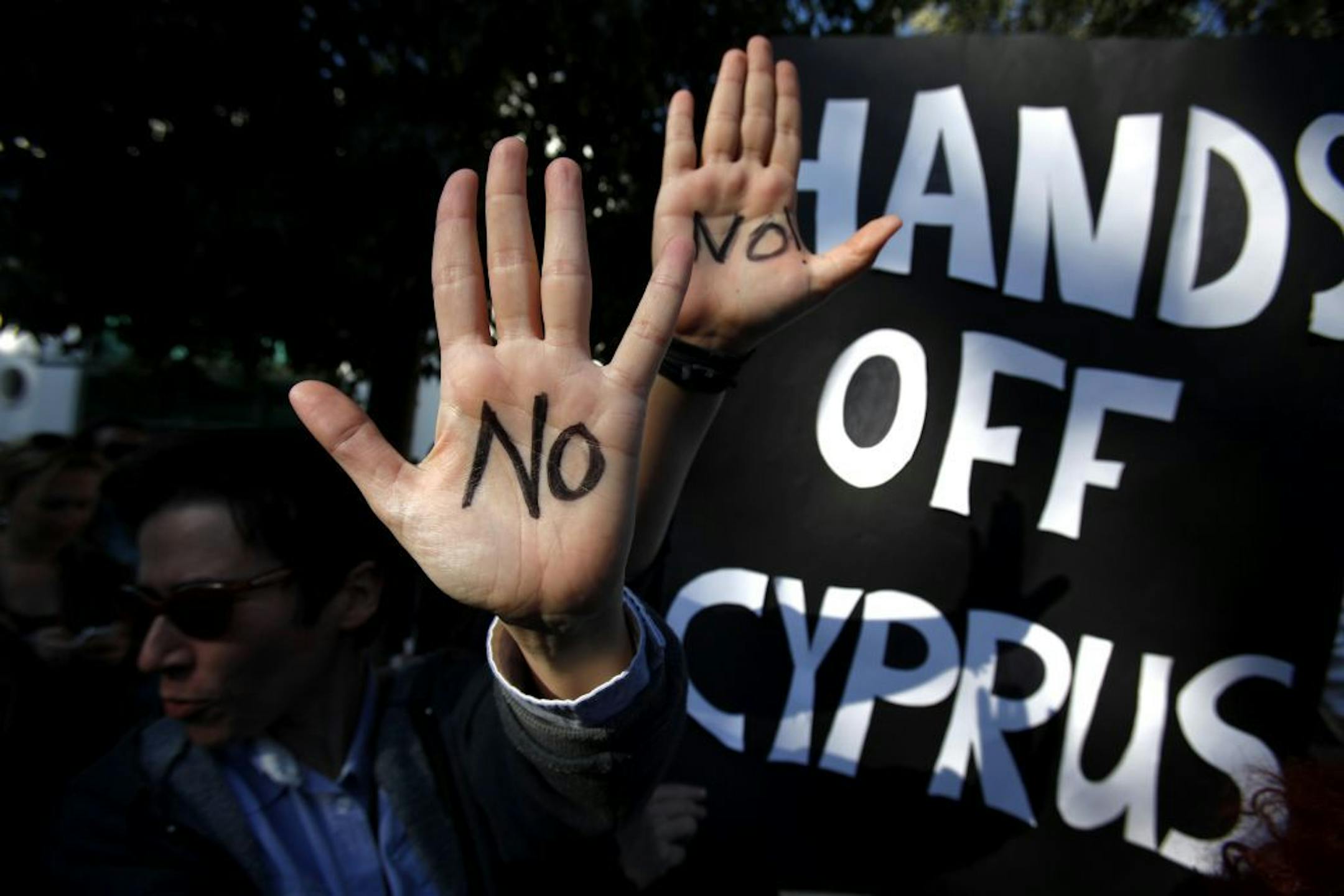 Protesters held up their hands as they protest outside the parliament in capital Nicosia, Cyprus on March 18, 2013.