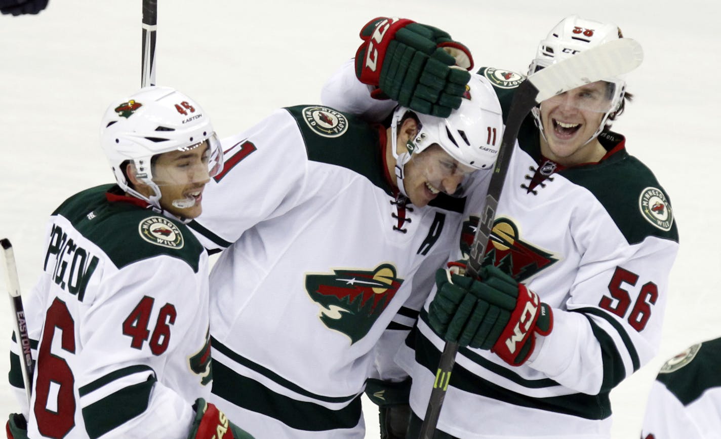 Minnesota Wild's Jared Spurgeon (46), Zach Parise (11), Erik Haula (56), of Finland, and Ryan Suter (20) celebrate Haula's third goal against the Columbus Blue Jackets during the third period of an NHL hockey game in Columbus, Ohio, Tuesday, Jan. 5, 2016. Minnesota won 4-2. (AP Photo/Paul Vernon)